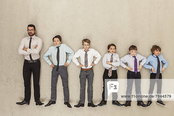 Businessman and boys standing in row