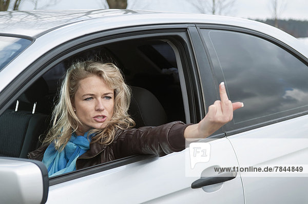Angry woman showing obscene gesture