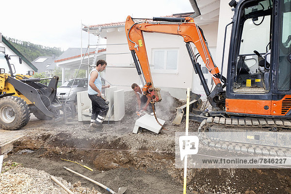 Europe  Germany  Rhineland Palatinate  Men working with corner stones during house building