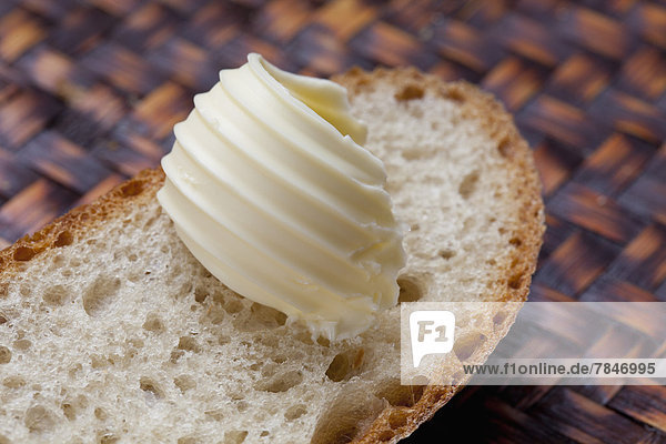 Slice of white bread with curl of butter close up