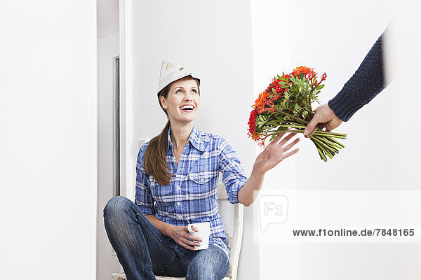 Human hand giving bunch of flowers to woman  smiling