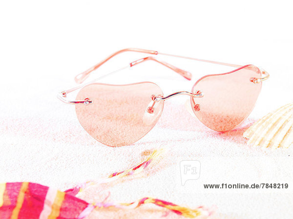 Herzförmige Sonnenbrille auf Sand  Nahaufnahme