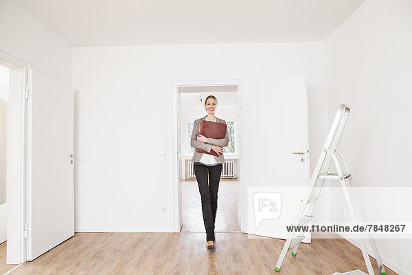 Woman with file walking on floor  smiling