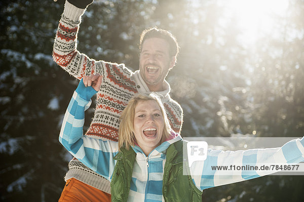 Österreich  Salzburg  Paar mit Spaß im Schnee