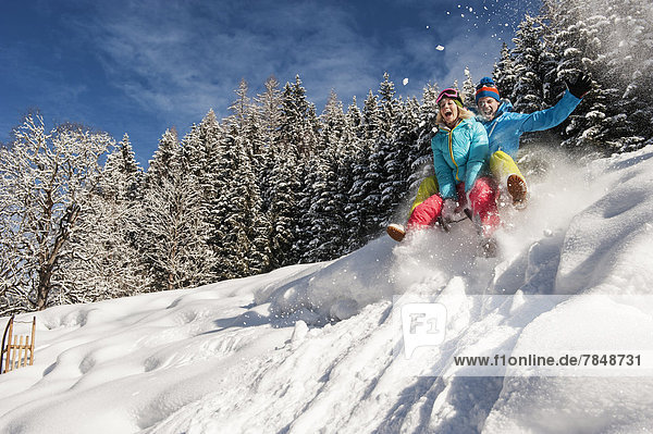 Austria  Salzburg  Young man and woman with sledge in snow at Altenmarkt Zauchensee