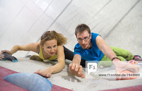 Young man and woman bouldering