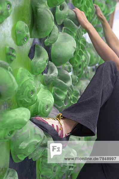 Junge Frau beim Bouldern