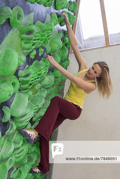 Junge Frau beim Bouldern