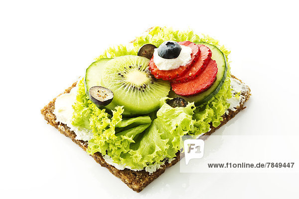 Fitness-Sandwich mit Frischkäse  Salat und Obstscheiben auf weißem Grund  Nahaufnahme