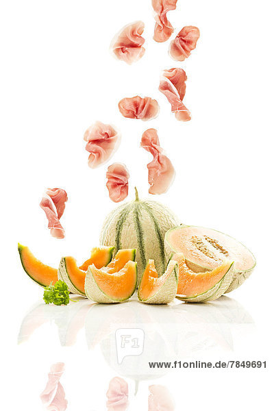 Zuckermelonen mit Schinken auf weißem Grund  Nahaufnahme