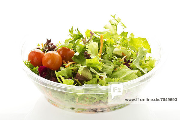 Schale mit gemischtem Salat auf weißem Hintergrund