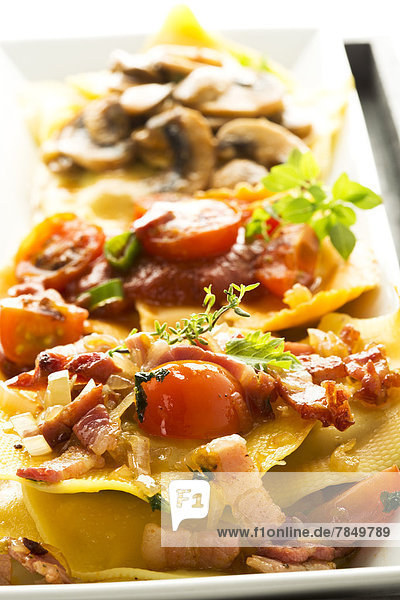 Verschiedene Ravioli gefüllt mit Tomaten  Schinken und Champignons auf dem Teller