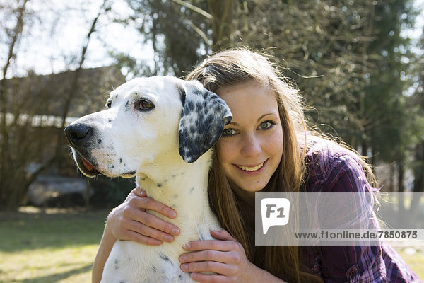Deutschland  Porträt eines jungen Mädchens mit dalmatinischem Hund  lächelnd