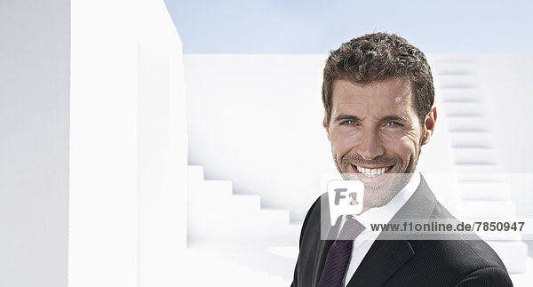 Porträt eines Geschäftsmannes im schwarzen Anzug  lächelnd