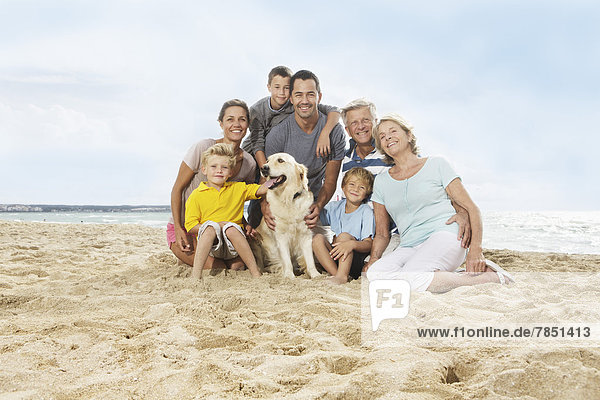 Spain  Portrait of family sitting on beach at Palma de Mallorca  smiling