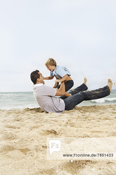 Spain  Father and son having fun on beach at Palma de Mallorca  smiling