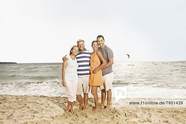 Spain  Family on beach at Palma de Mallorca  smiling