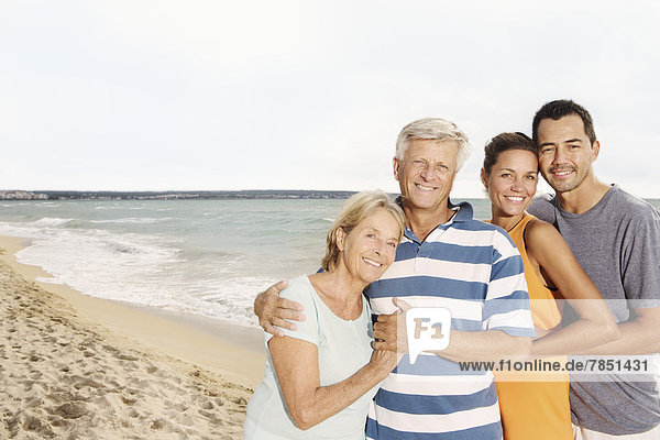 Spain  Family on beach at Palma de Mallorca  smiling