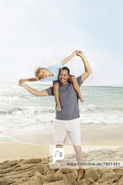 Spain  Father and son having fun on beach at Palma de Mallorca  smiling