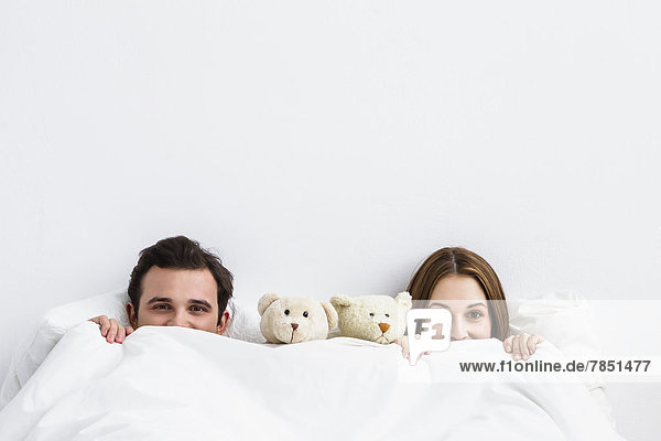 Portrait of young couple with teddy bear  smiling