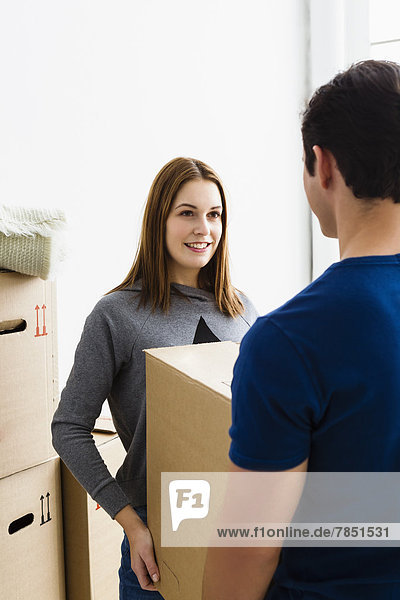 Germany  Munich  Young couple holding cardboard box  smiling