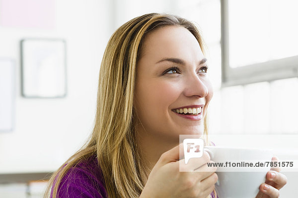 Young woman holding cup of tea  smiling