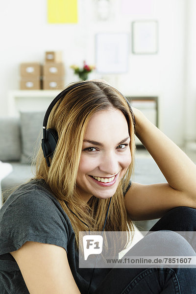 Portrait of young woman listening music  smiling
