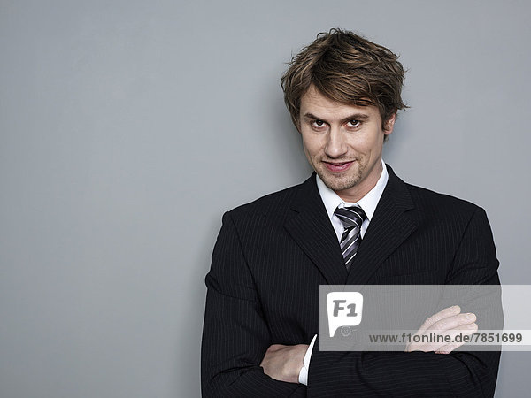Portrait of businessman standing with arms crossed  smiling