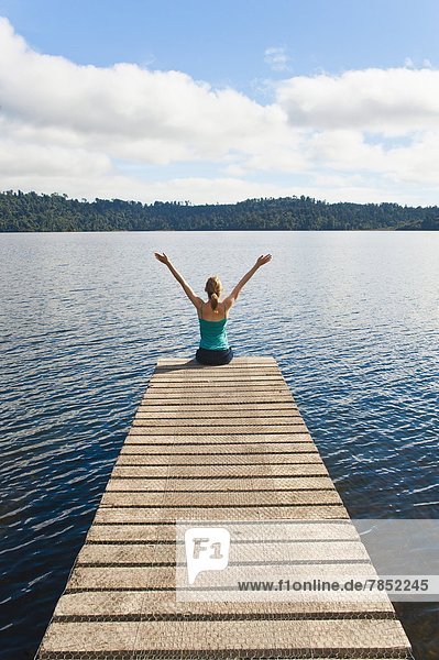 Woman sitting on a jetty  Lake Ianthe  West Coast  South Island  New Zealand  Pacific