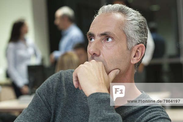 Mature man contemplating in office