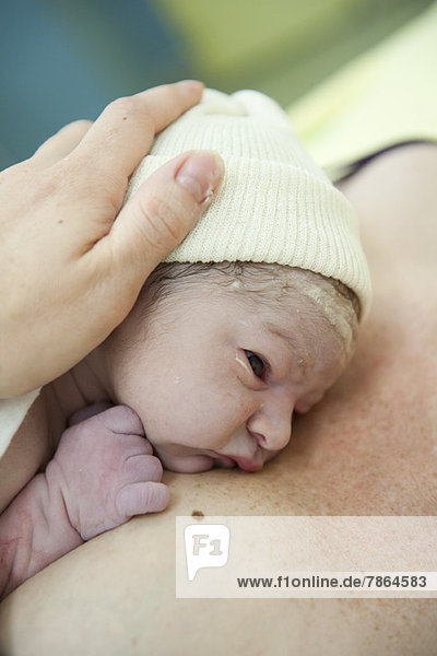 Newborn baby lying on mother's chest