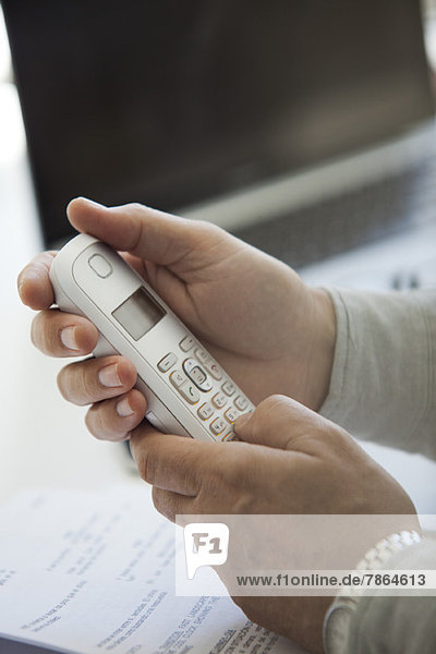 Man's hands holding cell phone  cropped