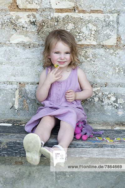 Kleines Mädchen auf dem Bordstein sitzend,  Portrait