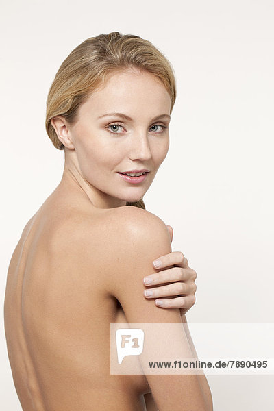 Nude Caucasian woman looking over shoulder