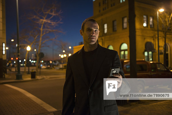 Caucasian man using cell phone on city street