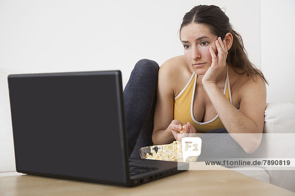 Europäer  Frau  Notebook  essen  essend  isst  Popcorn