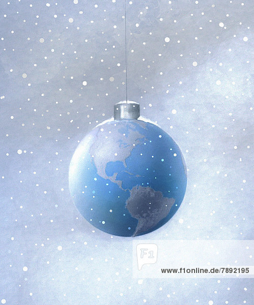 Snow falling around hanging globe Christmas ornament