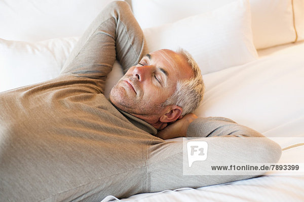 Man resting on the bed in a hotel room