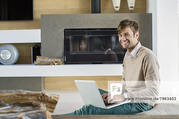 Portrait eines lächelnden Mannes mit einem Laptop