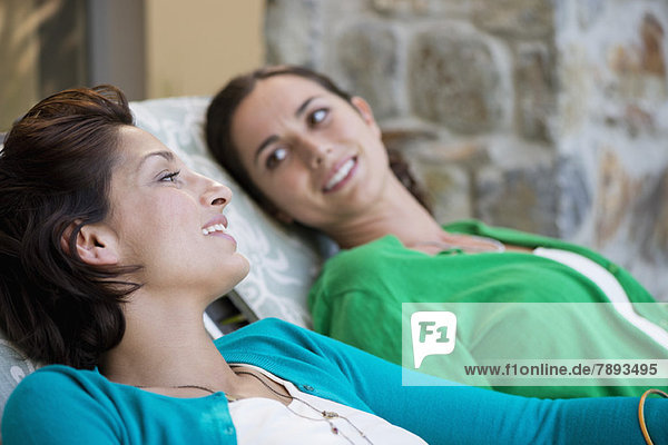 Two women relaxing on lounge chairs