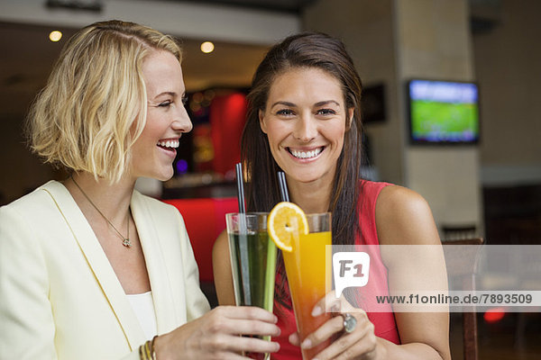 Two female friends enjoying drinks in a restaurant