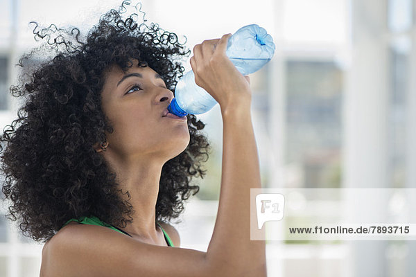 Close-up of a woman drinking water from a bottle