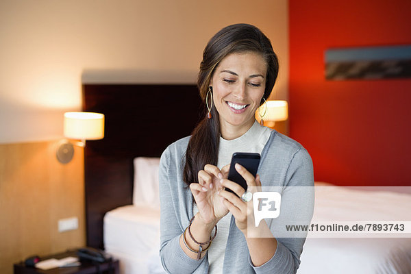 Woman using a cell phone in a hotel room