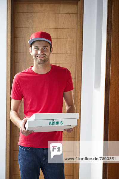 Portrait of a smiling deliveryman delivering pizza