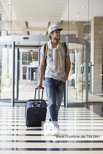Ein Mann  der sein Gepäck am Flughafen abholt.
