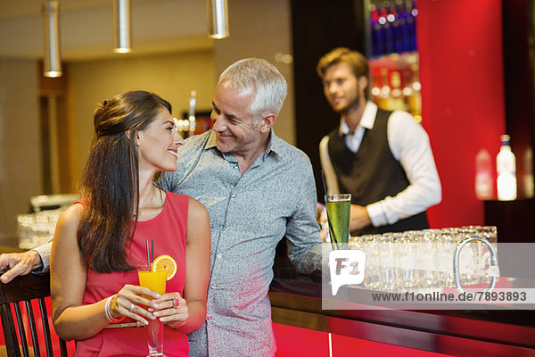 Couple enjoying drinks at the bar counter