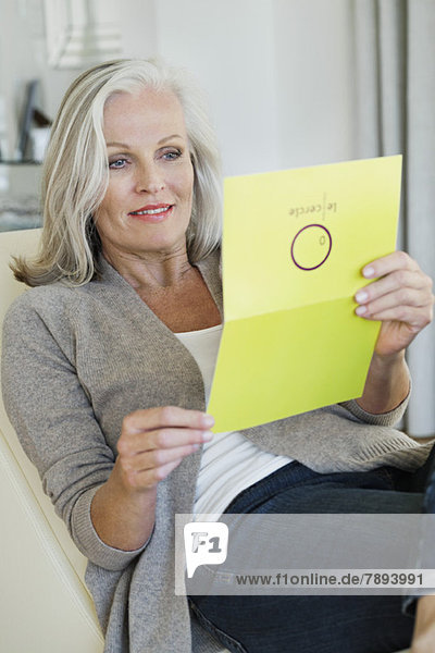 Senior woman reading a greeting card
