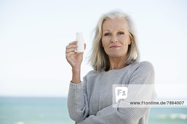 Woman holding a bottle of probiotic drink