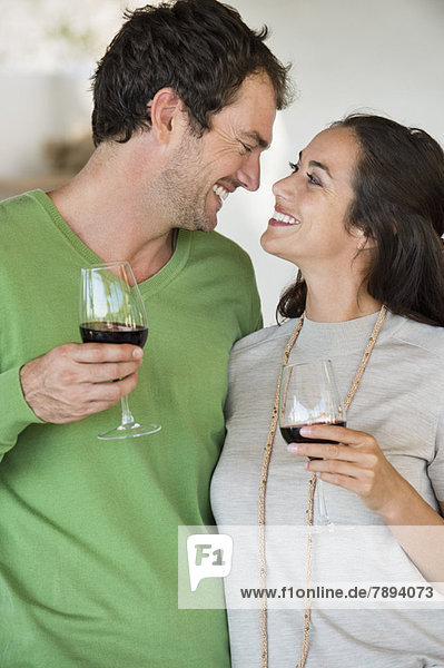 Couple holding wine glasses and smiling