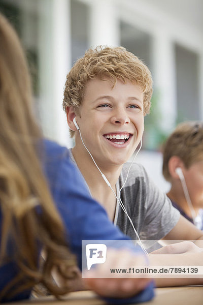 Schülerinnen und Schüler  die im Klassenzimmer Musik hören
